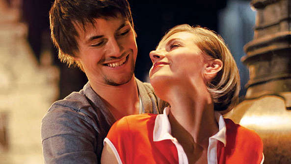 Happy couple in a square hugging under Philips lighting