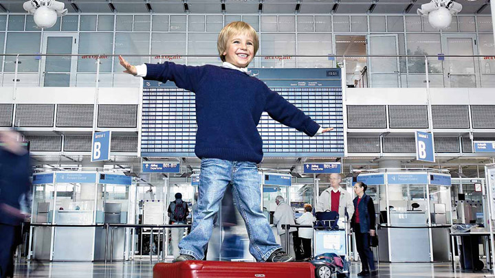 طفل يلعب في محطة مُضاءة جيدًا في المطار